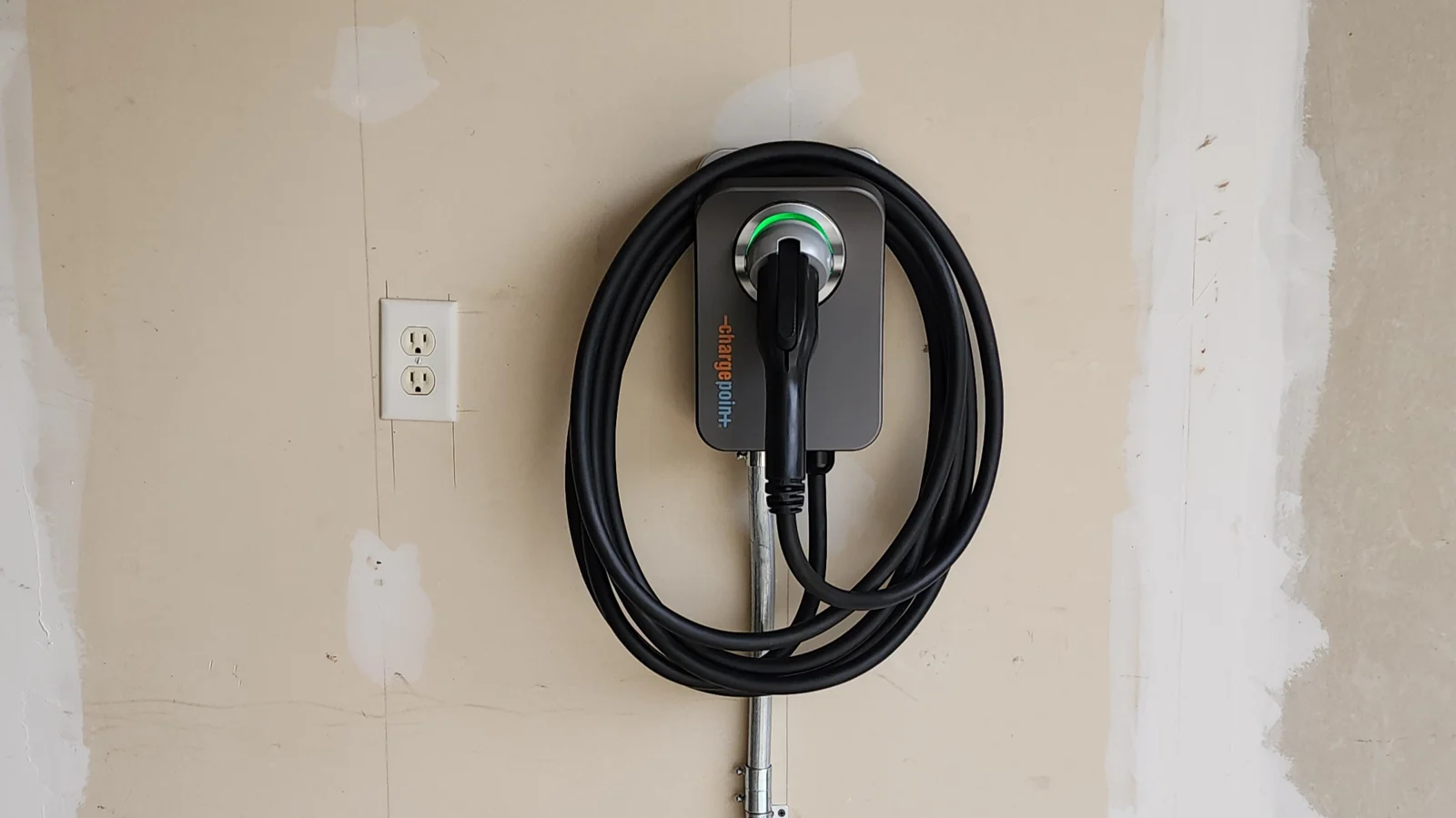 Wall-mounted charger with a cable neatly stored in the garage